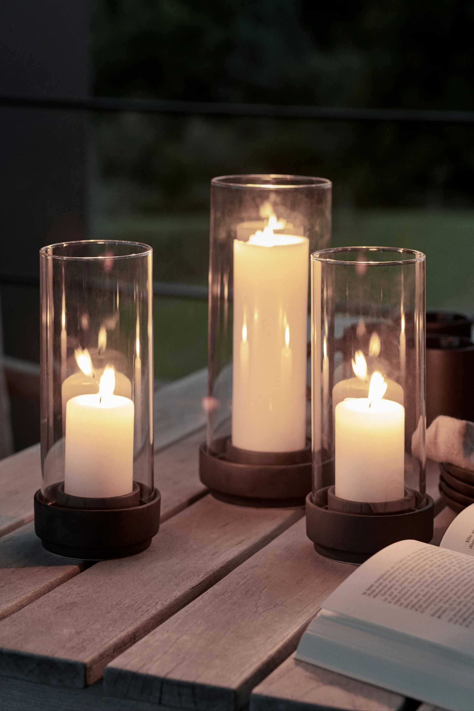 Dekorieren Sie Ihren Gartentisch mit Laternen und Windlichtern für draußen in verschiedenen Größen, um den Gemütlichkeitsfaktor zu erhöhen. Zu diesem Zweck eignen sich die Hurricane Windlichter von Stelton besonders gut.