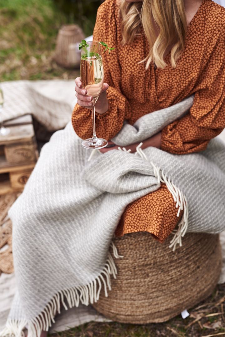 Jute-Sitzsack mit einer Decke und einem Glas Sekt. 