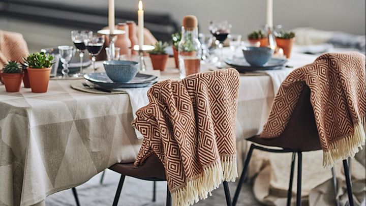 Modern gedeckter Tisch mit der Wolldecke Salt von Nordic Nest in Terrakotta auf dem Esszimmerstuhl. 