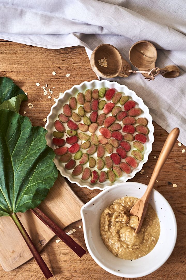 Einfaches und leckeres Sommerrezept für einen knusprigen Rhabarberkuchen in einer weißen Kuchenform.