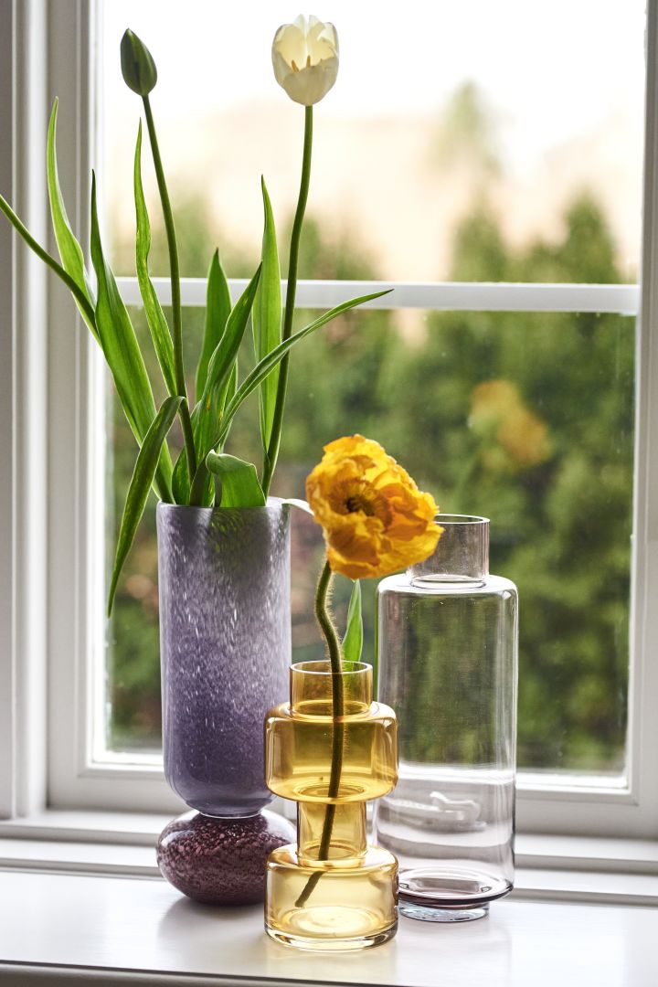 Bringen Sie Pastellfarben in Ihre Einrichtung, indem Sie mit der violetten Dorit Vase von Broste Copenhagen, der gelben Benette Vase von Bloomingville und der rosa  Vase von Lene Bjerre dekorieren.