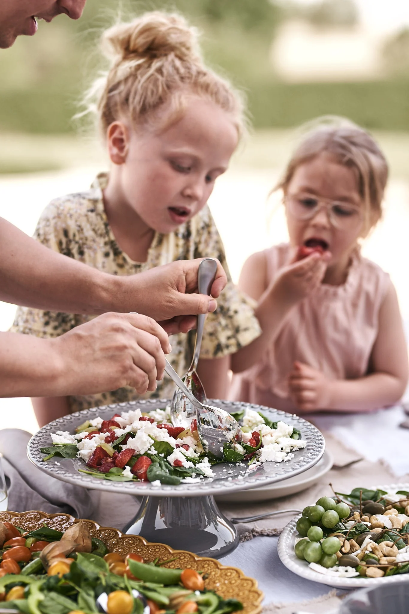 Zum sommerlichen Mittagessen wird ein frischer Sommersalat mit Erdbeeren und Fetakäse serviert, der bei den Kindern am Tisch sehr beliebt ist.