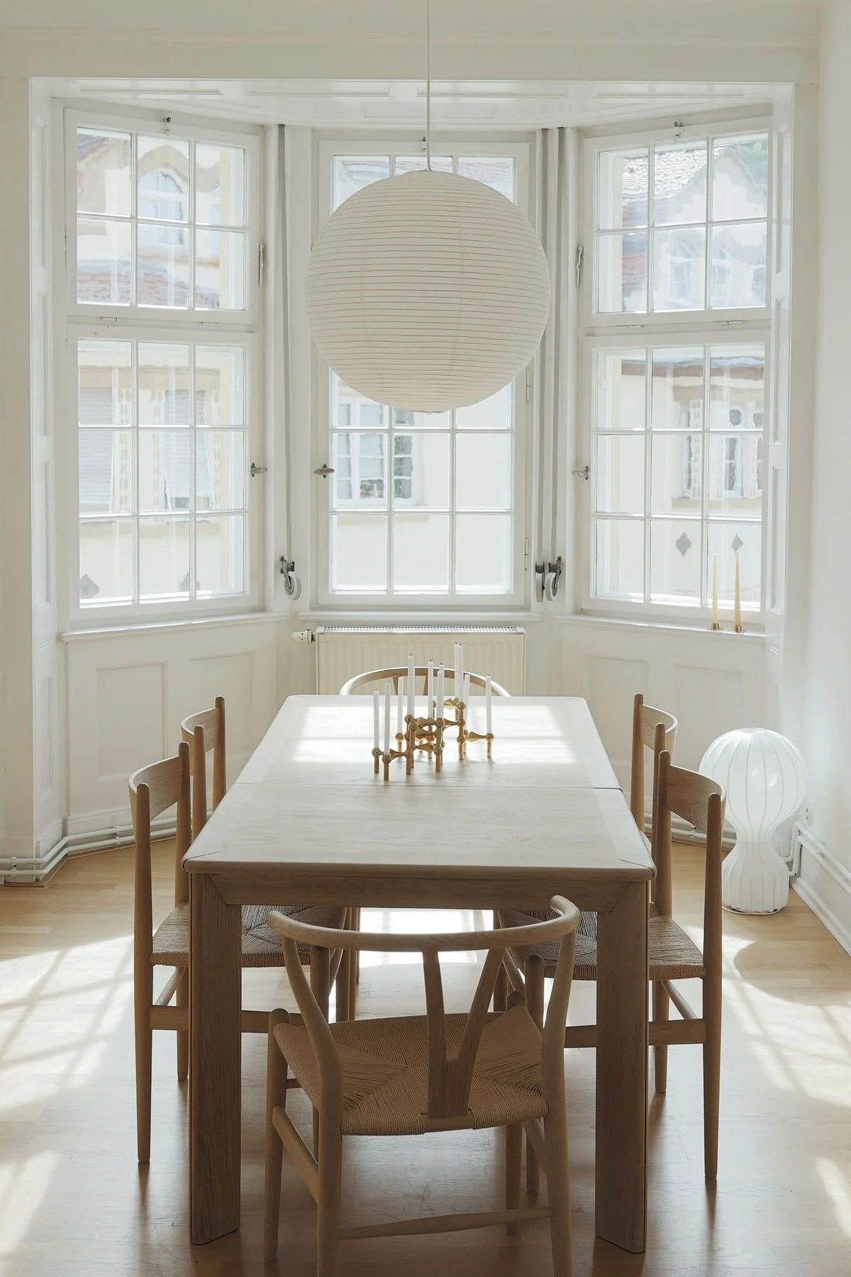 Eine Lagom-Einrichtung zeichnet sich durch Minimalismus aus. Hier sehen Sie das Esszimmer von @b.wohnbar mit einem großen Esstisch, Stühlen, hohen Fenstern und der Paper rice Pendellampe von HAY.