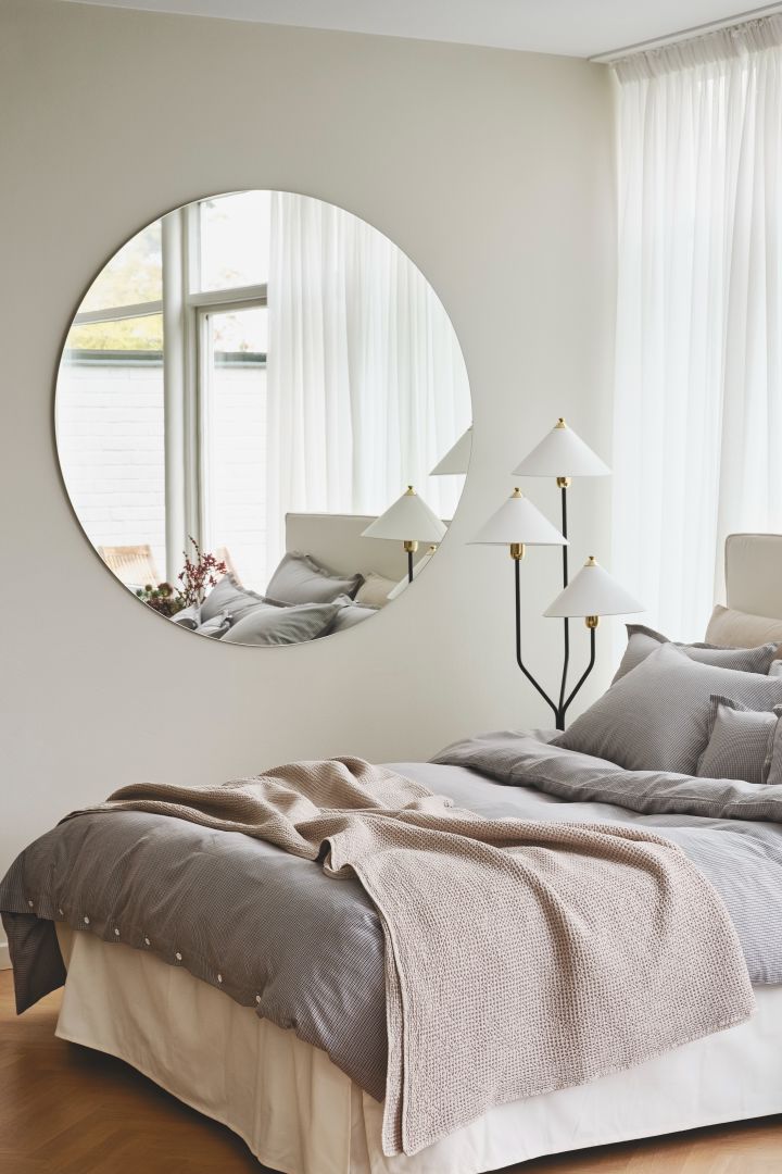 Schaffen Sie ein Schlafzimmer wie im Hotel: Mit einer schönen Tagesdecke, einer Blume in einer Vase und weißer Bettwäsche - wie hier von Mille Notti - schaffen Sie ein Schlafzimmer im Hotel-Stil.