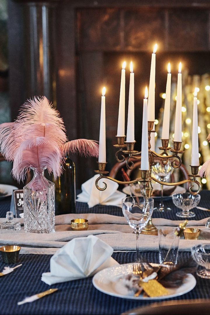 Ideen für Ihre Silvesterparty: Platzieren Sie einen Blickfang auf der Mitte des Tischs, beispielsweise in Form eines Kerzenhalters oder einer Vase.