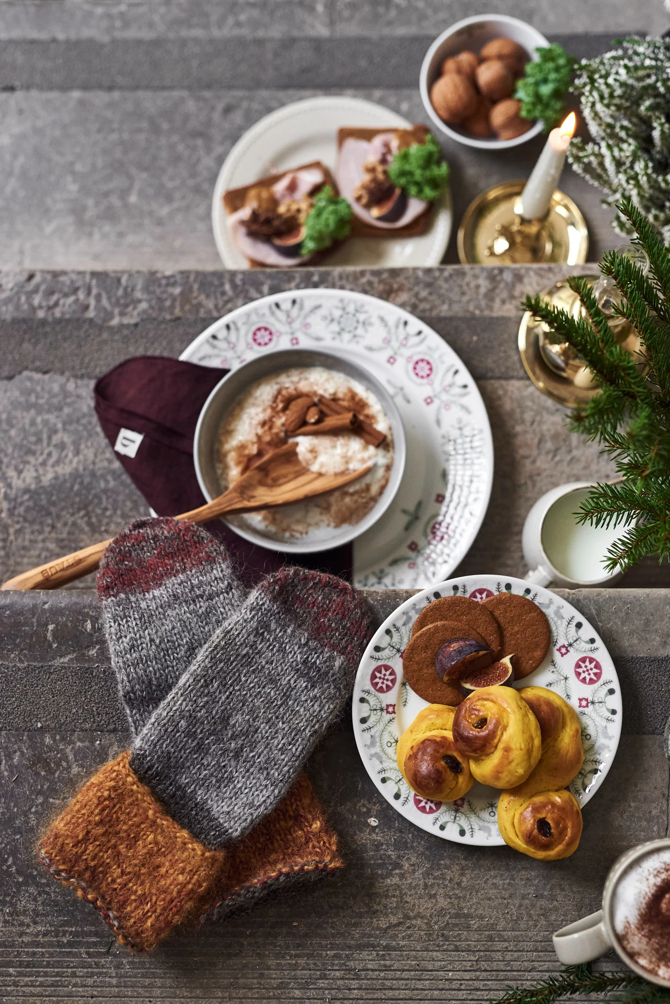 Auf einer Treppe stehen süße Leckereien wie Lussekatter und Milchreis, alle für den Jultomte, der Haus und Hof beschützen soll und die Geschenke bringt.