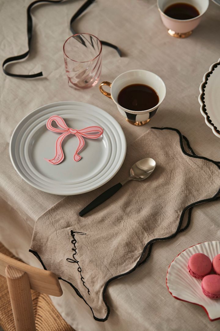 Decken Sie den Tisch für eine Galentine's-Feier mit Ihren liebsten Freundinnen. Hier sehen Sie Leinenservietten von Byon und schwarz-weiß gestreifte Teetassen von Hilke Collection. 