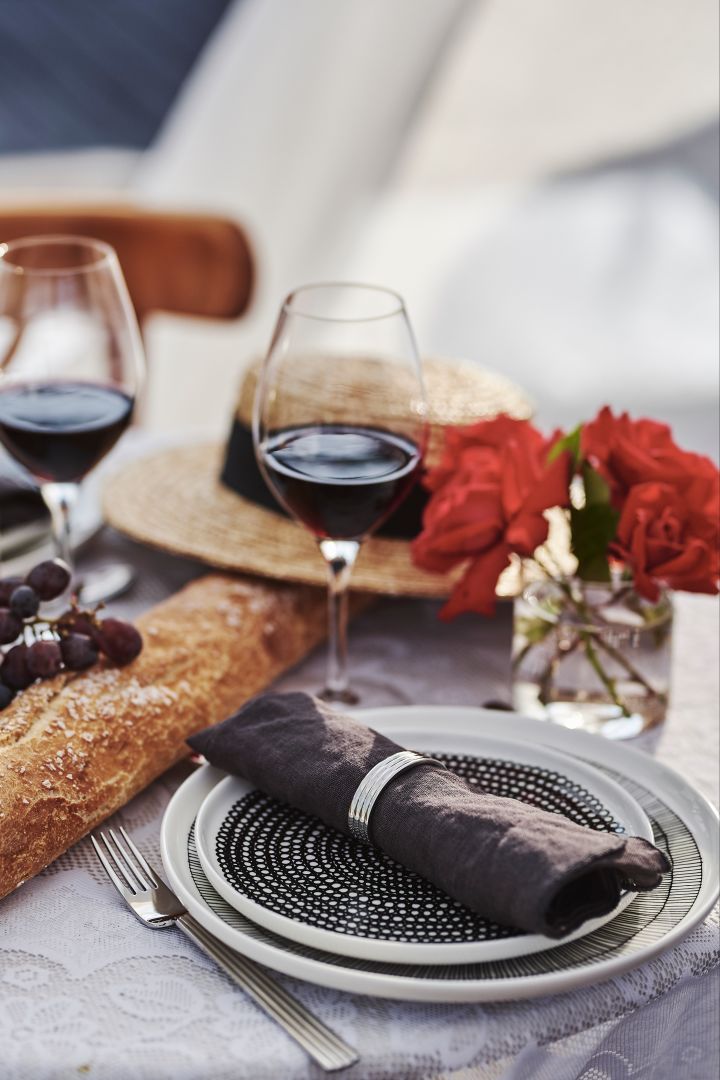 Tischdekoraktion im französischen Stil mit schwarz-weißem Porzellan, Rotweinglas und Baguette 