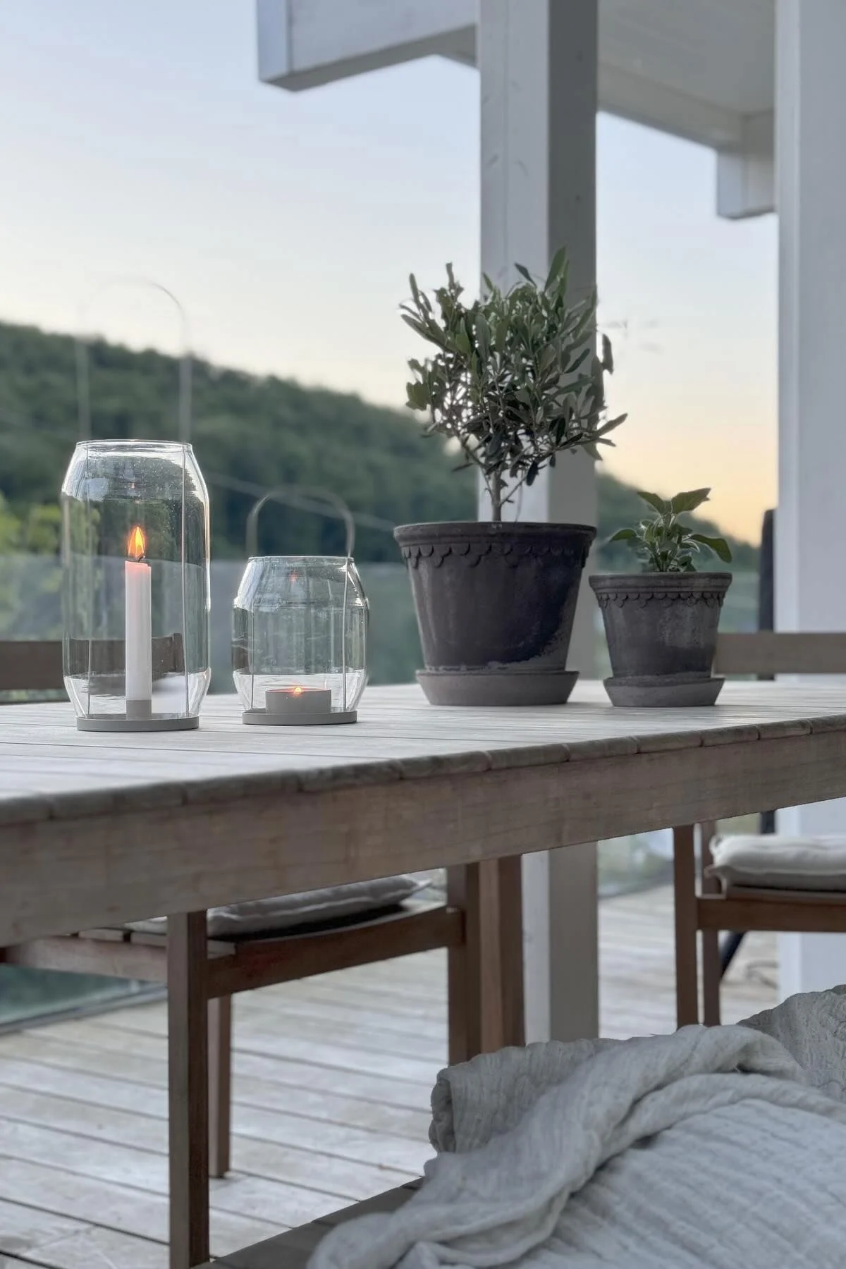 Zwei graue Kopenhagen-Blumentöpfe stehen auf einem Tisch, daneben zwei Ernst Laternen in verschiedenen Größen auf der Terrasse von @zuhauselig.