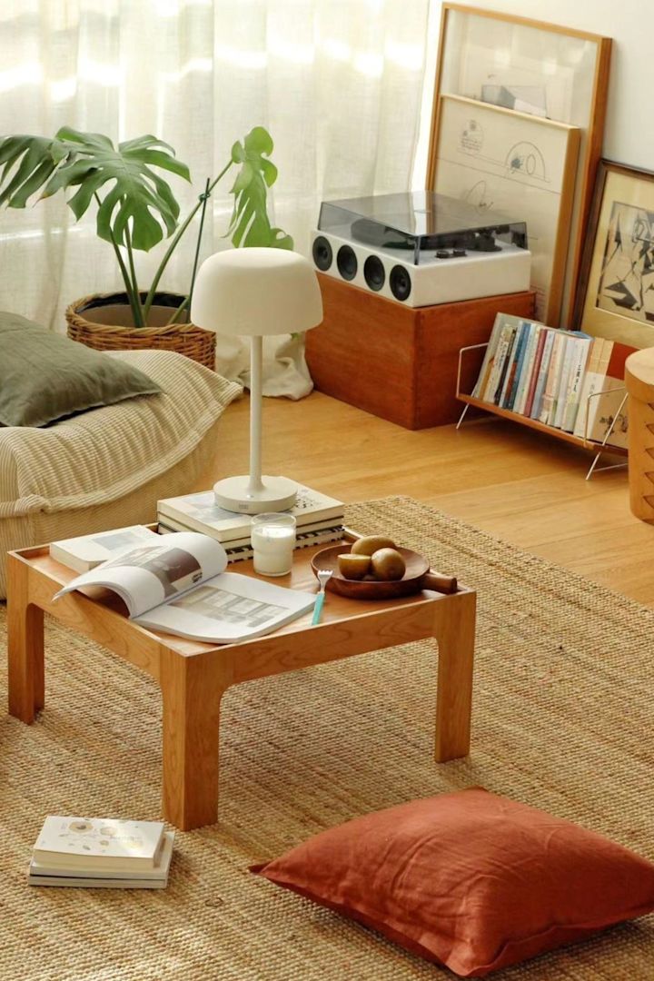 Die beigefarbene Tischlampe Halo von Scandi Living steht in einem Boho Style Wohnzimmer.