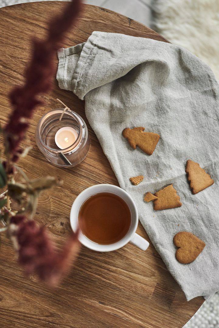 Ernst Becher und Kerzenlaterne mit Lebkuchen auf dem Tisch.