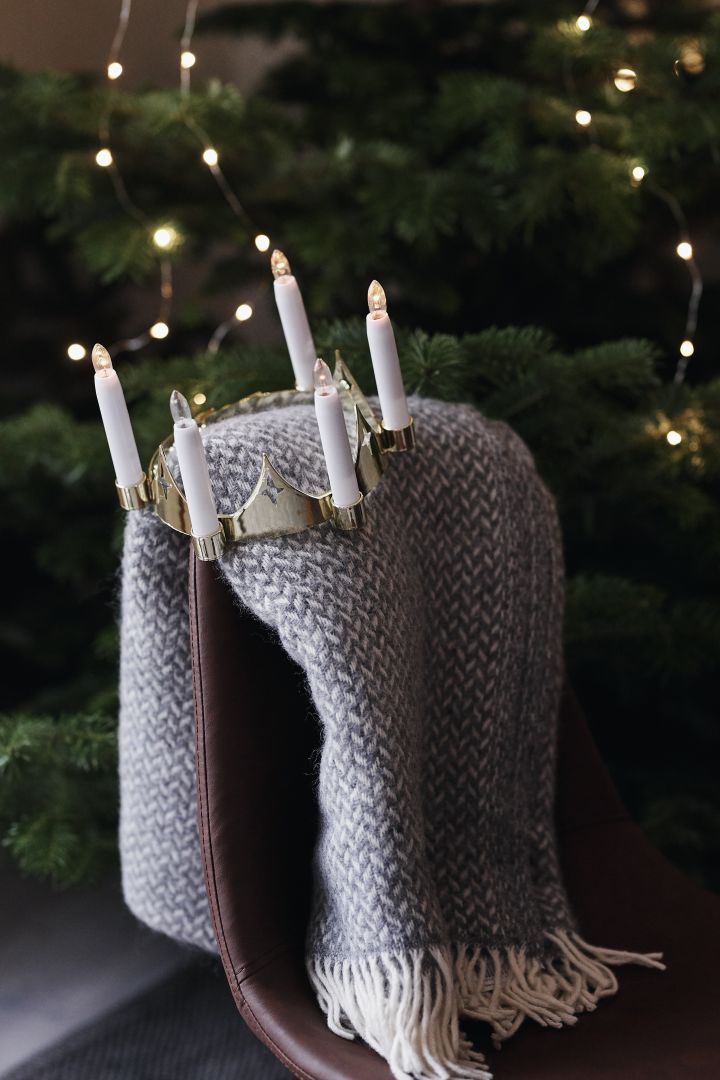 Geschenktipps zu Weihnachten: Hier sehen Sie die Polka-Wolldecke von Klippan Yllefabrik auf einem Stuhl vor einem Weihnachtsbaum.