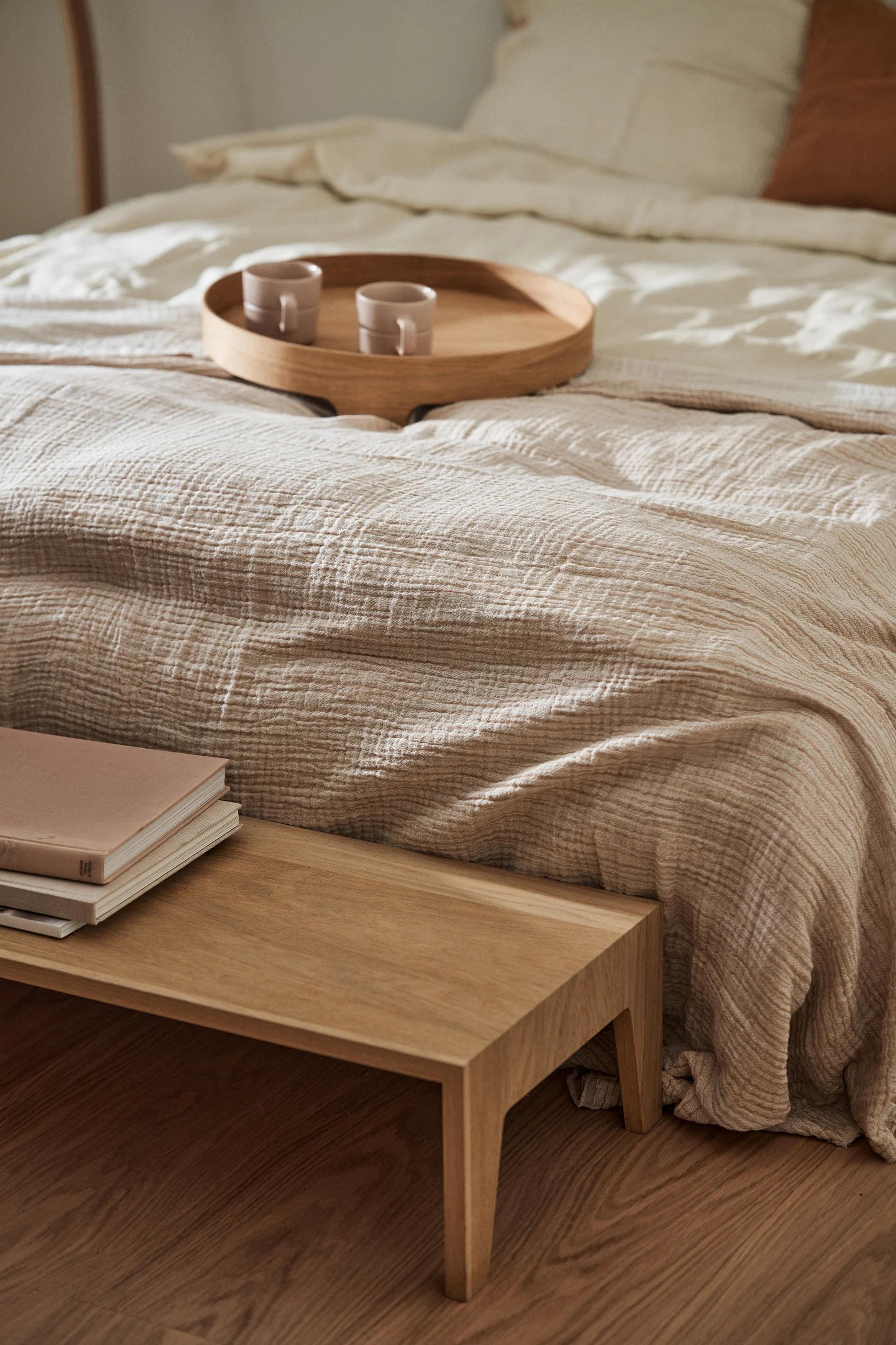 Feng Shui fürs Schlafzimmer zeichnet sich durch dezente Farben wie Beige und viele Textilien wie der Breeze Tagesdecke auf einem Bett aus.