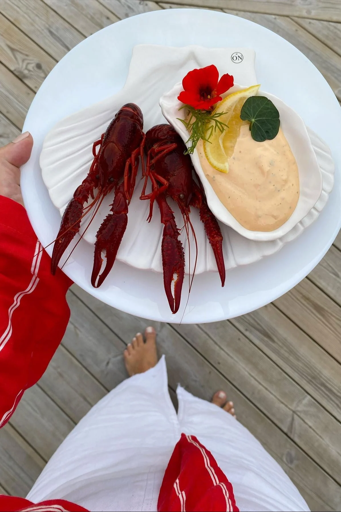 @evileer veranstaltete ein Krebsfest in Schweden und hält hier einen Teller mit zwei Flusskrebsen in der Hand, darauf der Shell Teller XL und die Oyster Schale mit Sauce, beides von Byon.