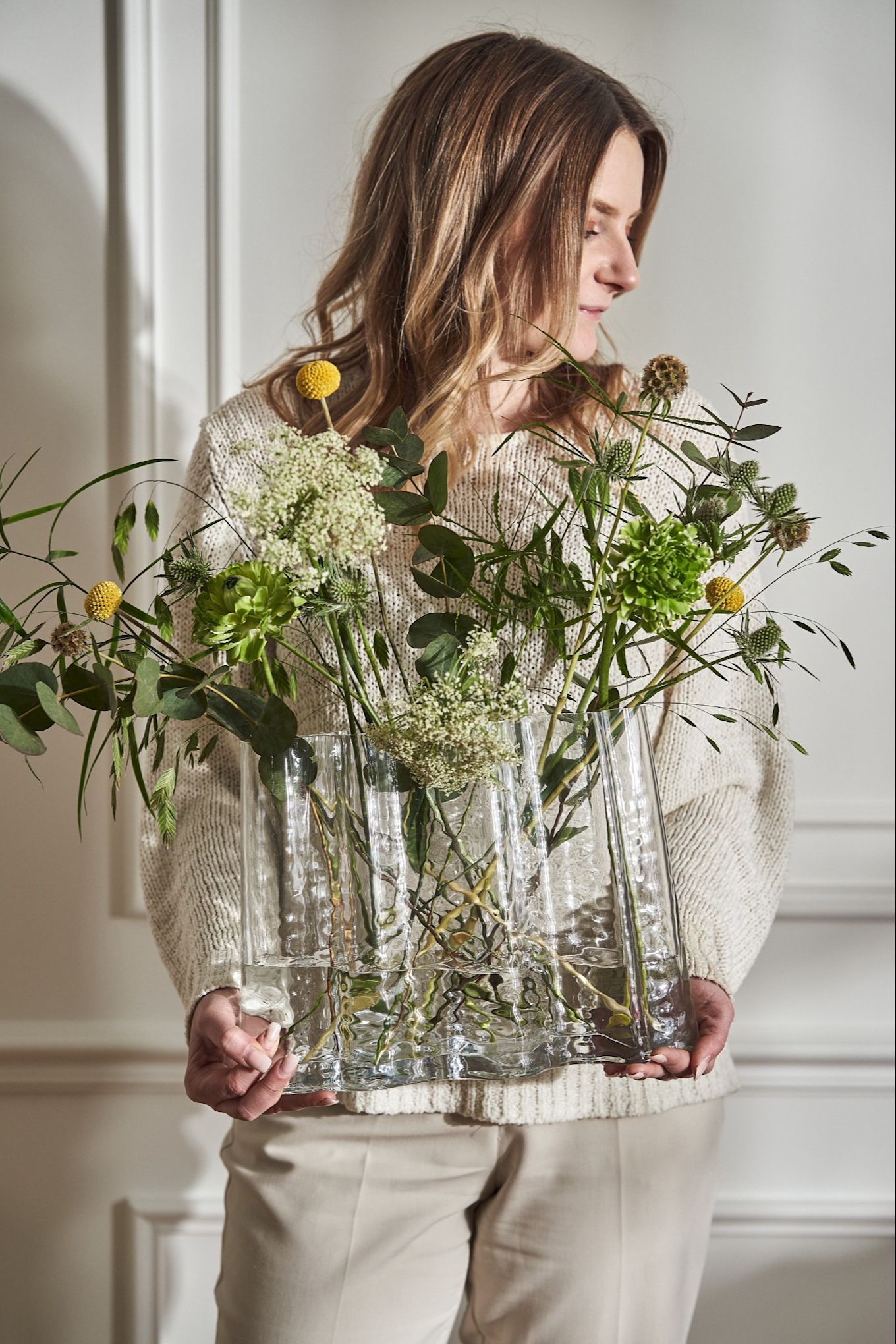 Es ist nicht immer einfach, die beste Vase für Ihre Schnittblumen zu finden. Hier sehen Sie die Vase Gry von Cooee Design, die von einer Frau gehalten wird.