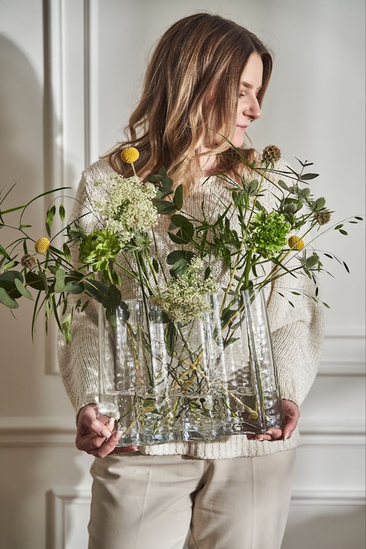 Es ist nicht immer einfach, die beste Vase für Ihre Schnittblumen zu finden. Hier sehen Sie die Vase Gry von Cooee Design, die von einer Frau gehalten wird.