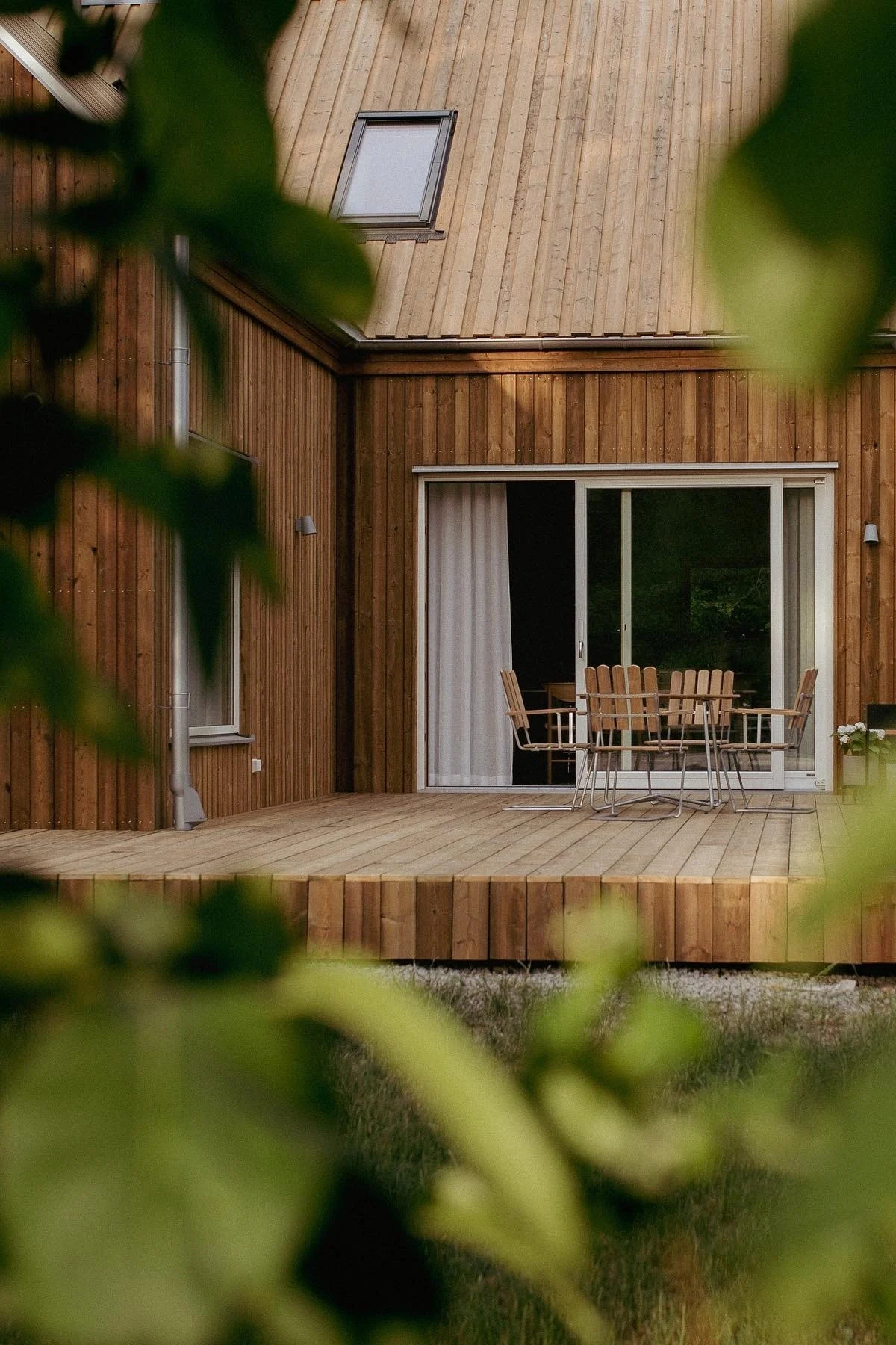 Grythyttan: Eine skandinavische Terrasse aus Holz mit der Klassiker-Serie, bestehend auf Stühlen und einem runden Tisch.