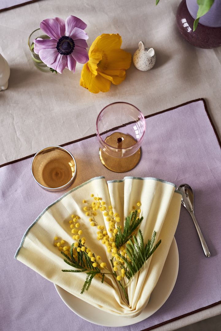 Gestalten Sie einen festlichen Ostertisch in frühlingshaften Pastelltönen mit der gelben Stoffserviette Contour und dem lila Tablett von HAY.