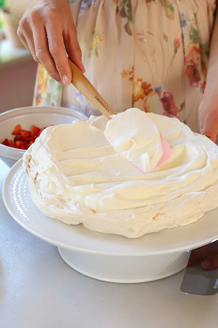Für die Himbeertorte wird der Baiserboden mit Sahne bestrichen, hier mit einem Spatel von Le Creuset.