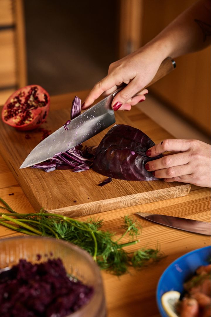 Schwedisches Weihnachtsessen: Ein Rotkohl wird mit dem Norden Chefs Messer von Fiskars für einen weihnachtlichen Salat mit Granatapfel geschnitten. 