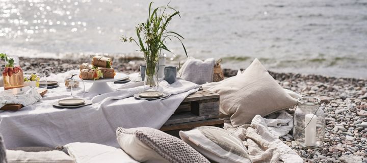 Ein luxuriöses Picknick am Strand mit Paletten als Tische.