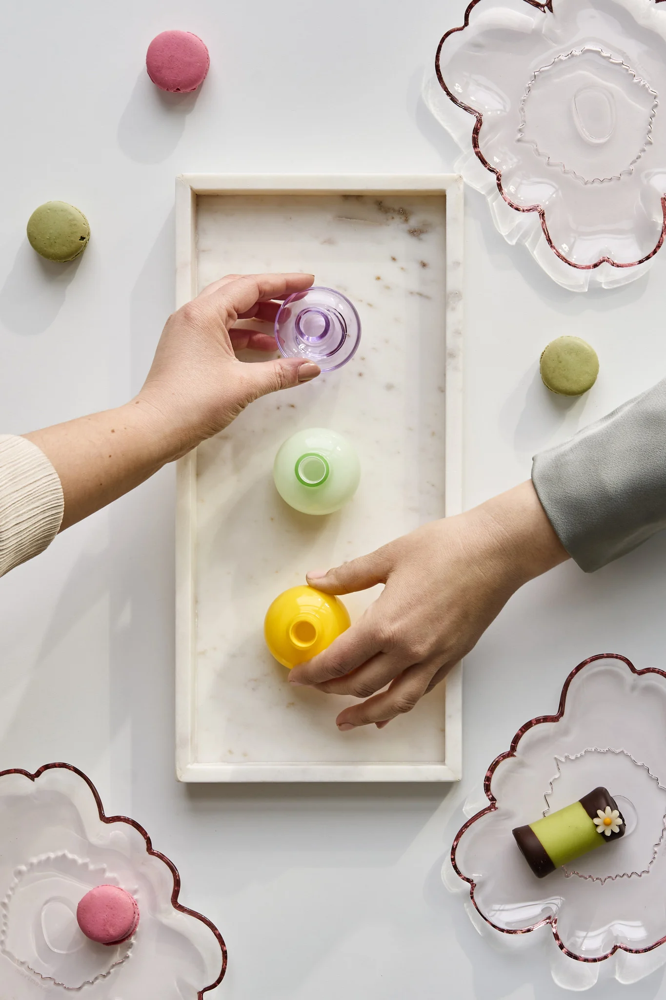 So veranstalten Sie eine unvergessliche Party: In den Händen halten Sie Mini-Vasen in verschiedenen Farben, die Sie als Partygeschenke mit nach Hause nehmen können.