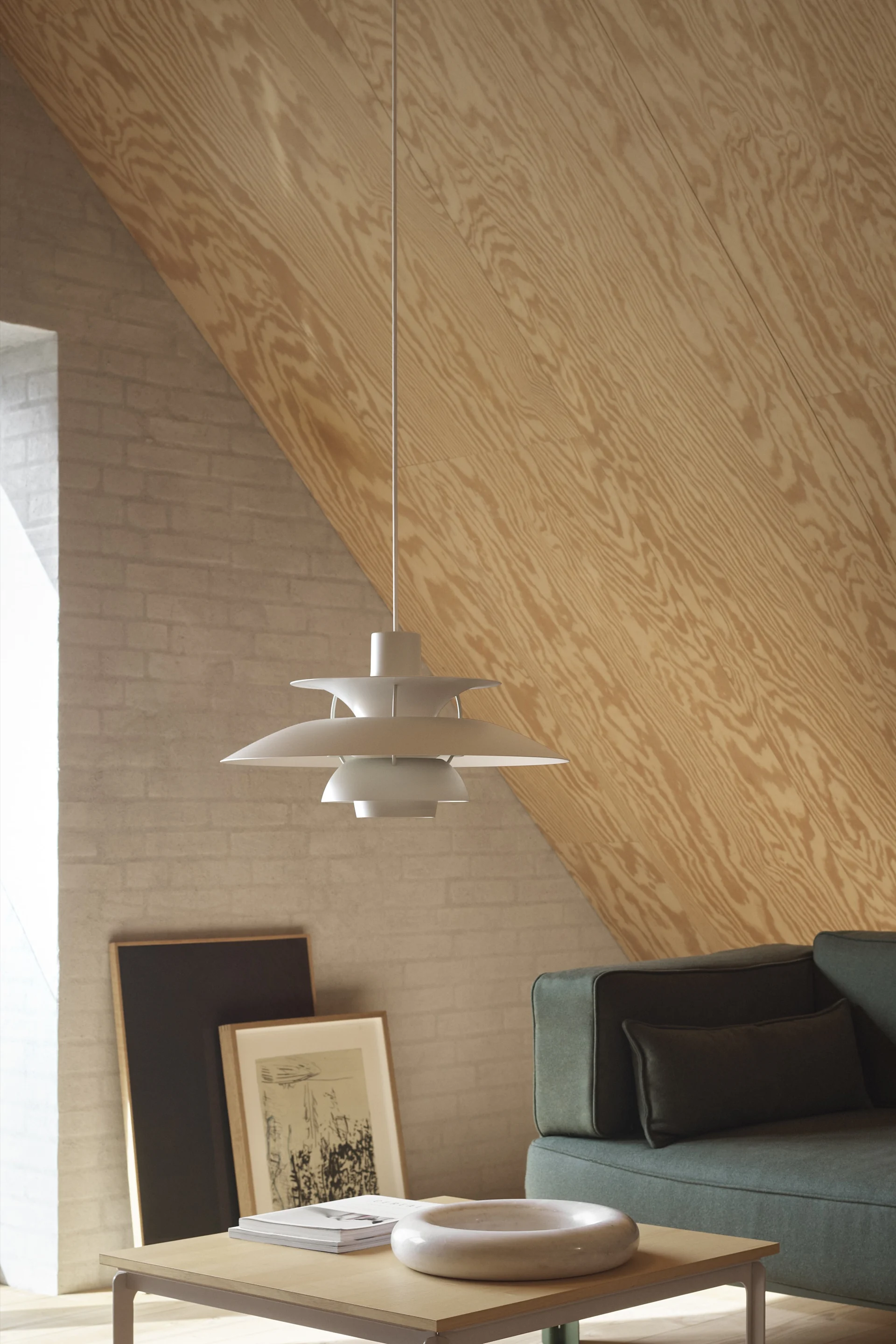 Skandinavische Lampen: Die PH 5 Mini-Pendelleuchte von Louis Poulsen hängt in einem skandinavischen Wohnbereich.