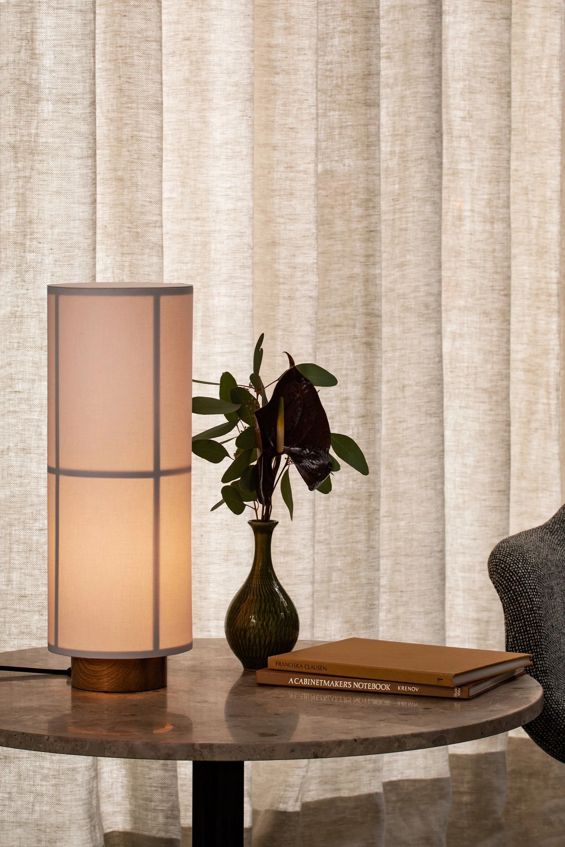 Skandinavische Lampen: Hier steht die im Japandi-Stil designte Hashira Tischleuchte von Audo Copenhagen auf einem Beistelltisch.