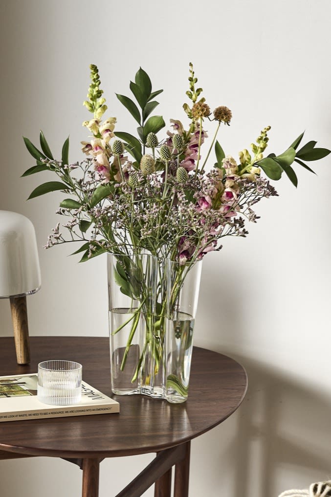 Hier sehen Sie die Alvar Aalto Vase von Iittala auf dem Beistelltisch, die am besten geformte Vase für langstielige Blumen wie Lilien. 