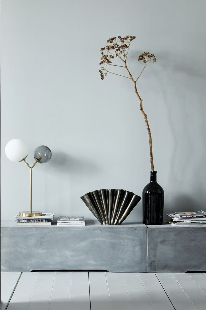 Ganz in Schwarz und Grau gehalten, überzeugt dieses Stillleben mit Lampen und Vasen in verschiedenen Höhen jeden Designfan.