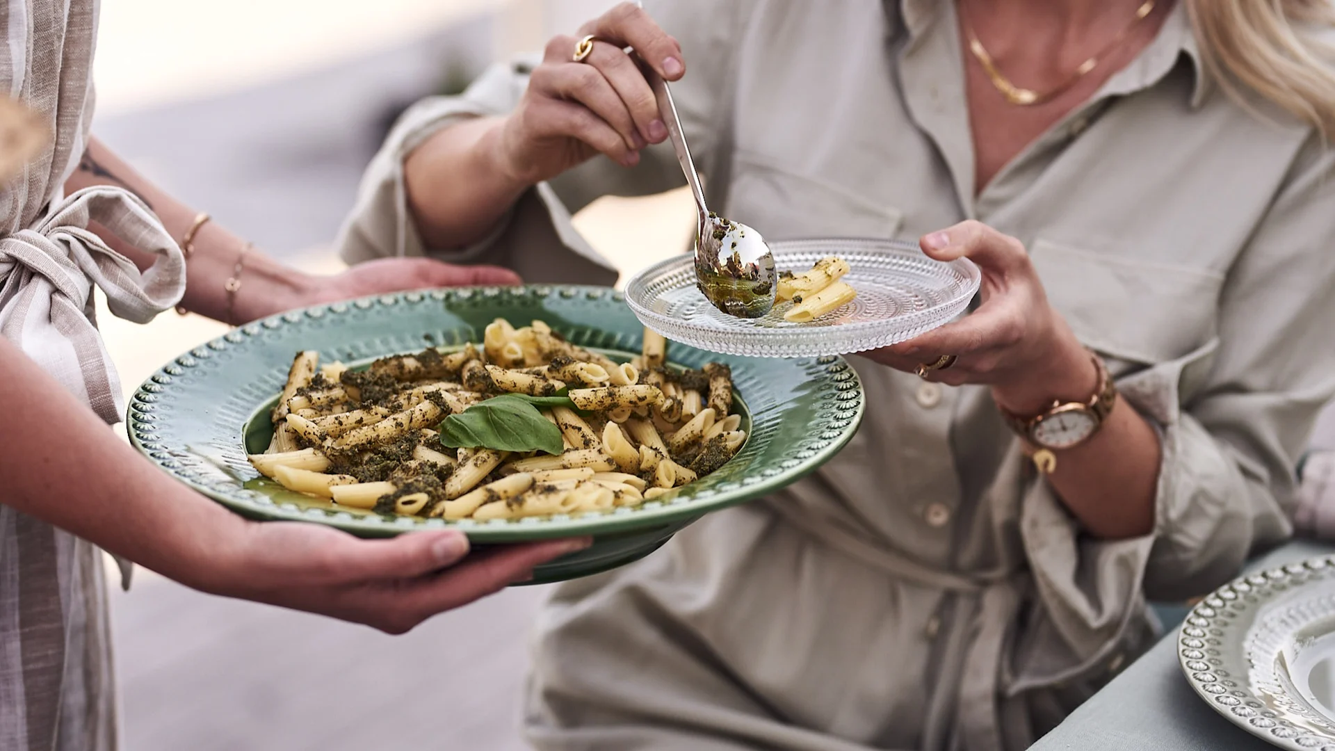Auf der Gartenparty wird vegetarische Pasta aus einer grünen Servierschale von PotteryJo serviert.