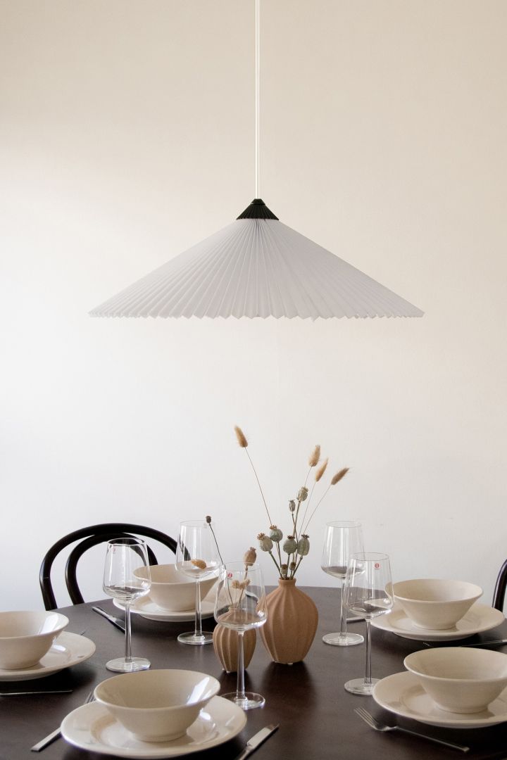 Beleben Sie Ihr Zuhause mit modernen Deckenleuchten – hier sehen Sie die Matisse Pendelleuchte von Globen Lighting aus gefaltetem Material, die jedem Essen eine gemütliche Atmosphäre verleiht. 