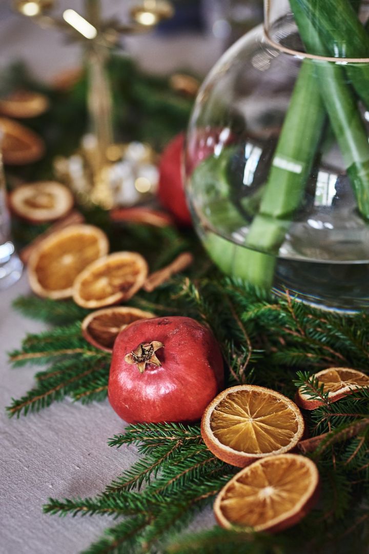 Weihnachtliche Tischdeko wie im Märchen: Schmücken Sie den Tisch mit Tannengrün, Granatäpfeln und getrockneten Orangenscheiben.