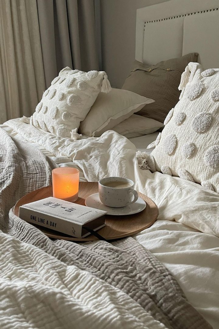 In unserer Herbst To-do-Liste geben wir Ihnen zahlreiche Tipps, was Sie diesen Herbst Skandinavisches machen können – zum Beispiel sich mit einem Buch im Bett einkuscheln.