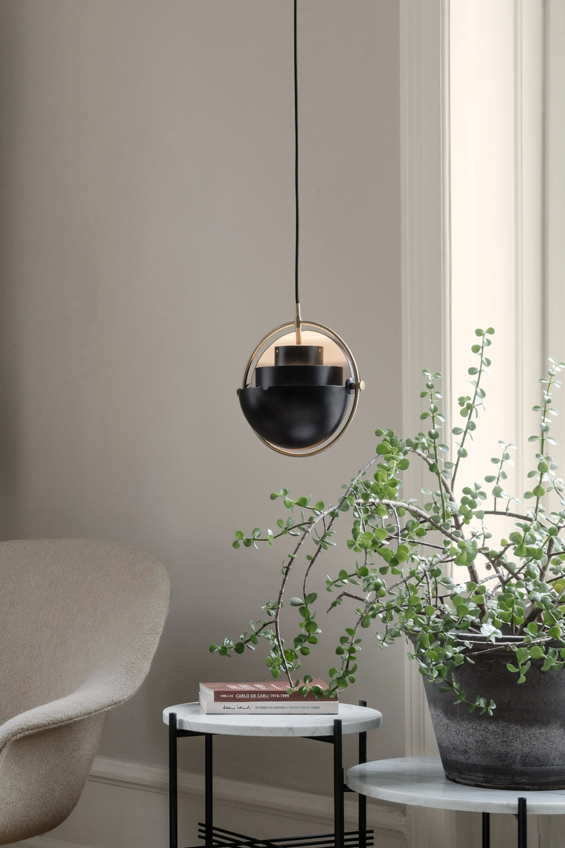 11 stylische Pendelleuchten für Ihr Wohlfühlzuhause -  hier sehen Sie die Multi-Lite Pendelleuchte von GUBI über einer Pflanze hängen. 