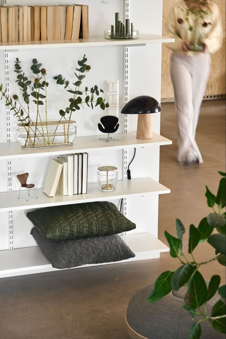 Hier sehen Sie ein Regal mit zahlreichen Produkten von Fritz Hansen dekoriert, darunter die Ikebana Vasen in verschiedenen Formen und Größen, sowie die Night Owl Tischleuchte.