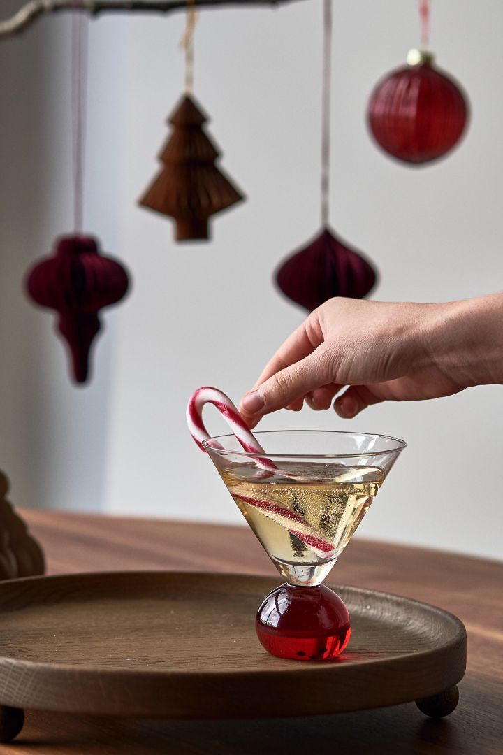 Einfache Weihnachtscocktails: Mischen Sie Glühwein mit Sekt und servieren Sie das Getränk in einem Glas aus der Spice-Kollektion von Byon und einer Zuckerstange.