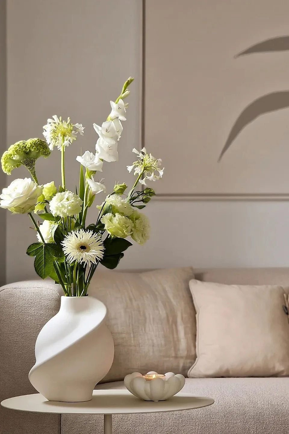 Die weiße Pirout Vase von Louise Roe steht auf einem Couchtsch in einem Wohnzimmer in Beige im Zuhause von @homagine.