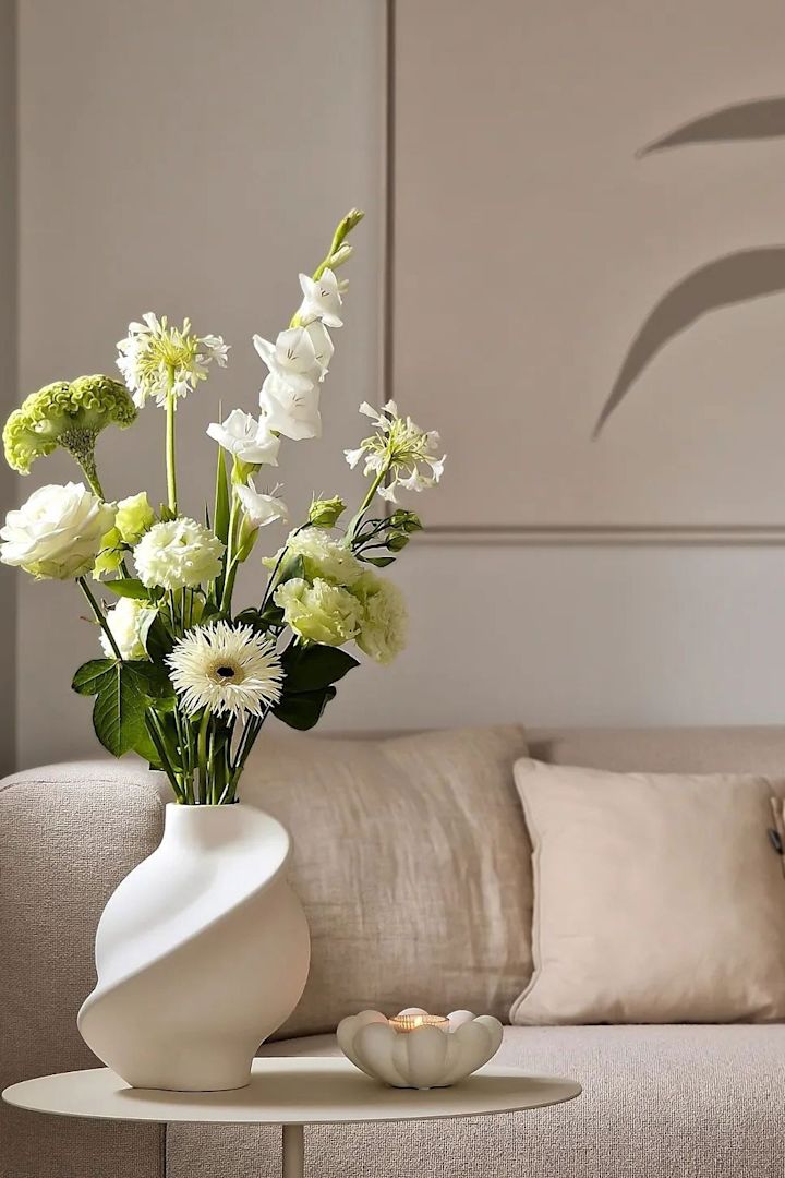 Die weiße Pirout Vase von Louise Roe steht auf einem Couchtsch in einem Wohnzimmer in Beige im Zuhause von @homagine.