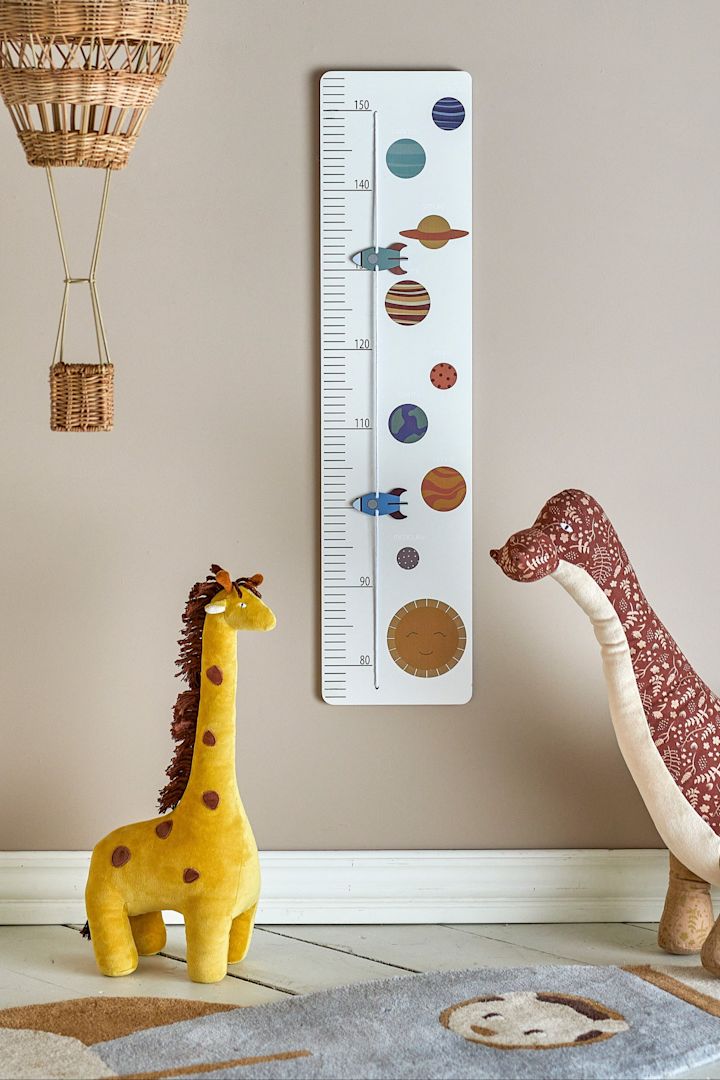 Mit dem niedlichen Space Messstab von Bloomingville können Eltern die Größe Ihres Babys über einige Jahre hinweg messen. Hier sehen Sie den Messstab an der Wand eines fantasievoll dekorativen Kinderzimmers hängen.