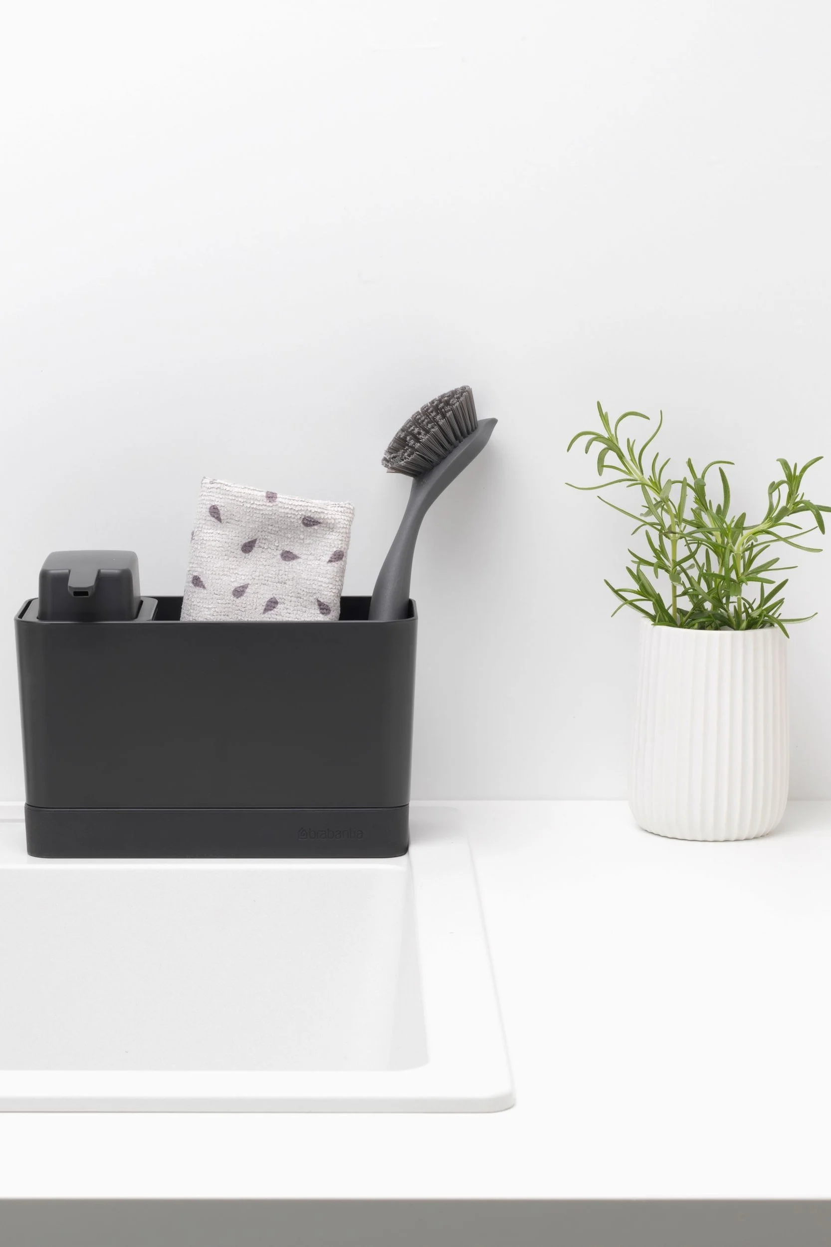 Reinigen Sie Ihre Bratpfanne mit dem Spülbecken Organizer von Brabantia, der einen Seifenspender, ein Spültuch und eine Spülbürste beinhaltet.