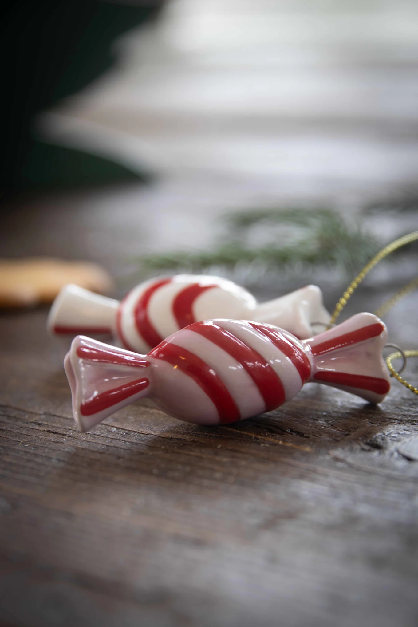 Die Candy Dekorationsanhänger von Pluto Design gehören zur Weihnachtsdeko 2025 und liegen hier auf einem Tisch.