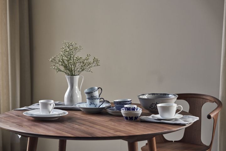 Auf einem runden Tisch sind die Porzellanklassiker von Rörstrand aufgereiht: Mon Amie, Swedish Grace, Ostindia in Blau und Schwarz und die Kanne Pli Blanc. 