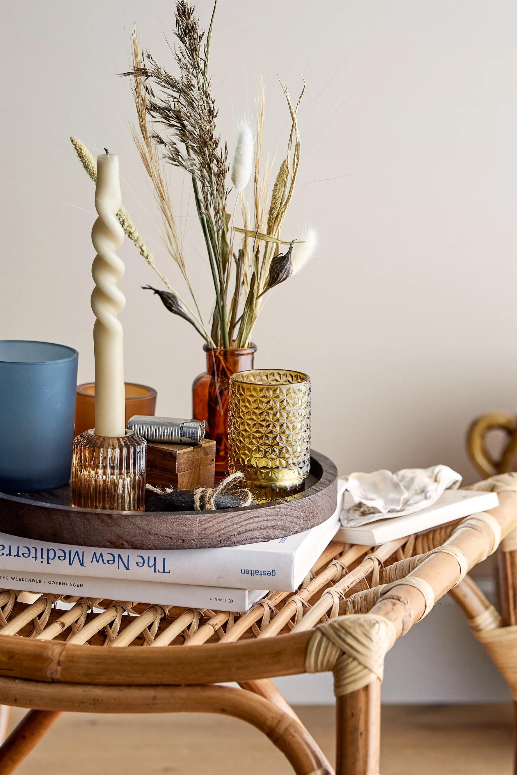 Auf einem Couchtisch im Boho-Stil steht ein Tablett mit Windlichtern von Bloomingville.