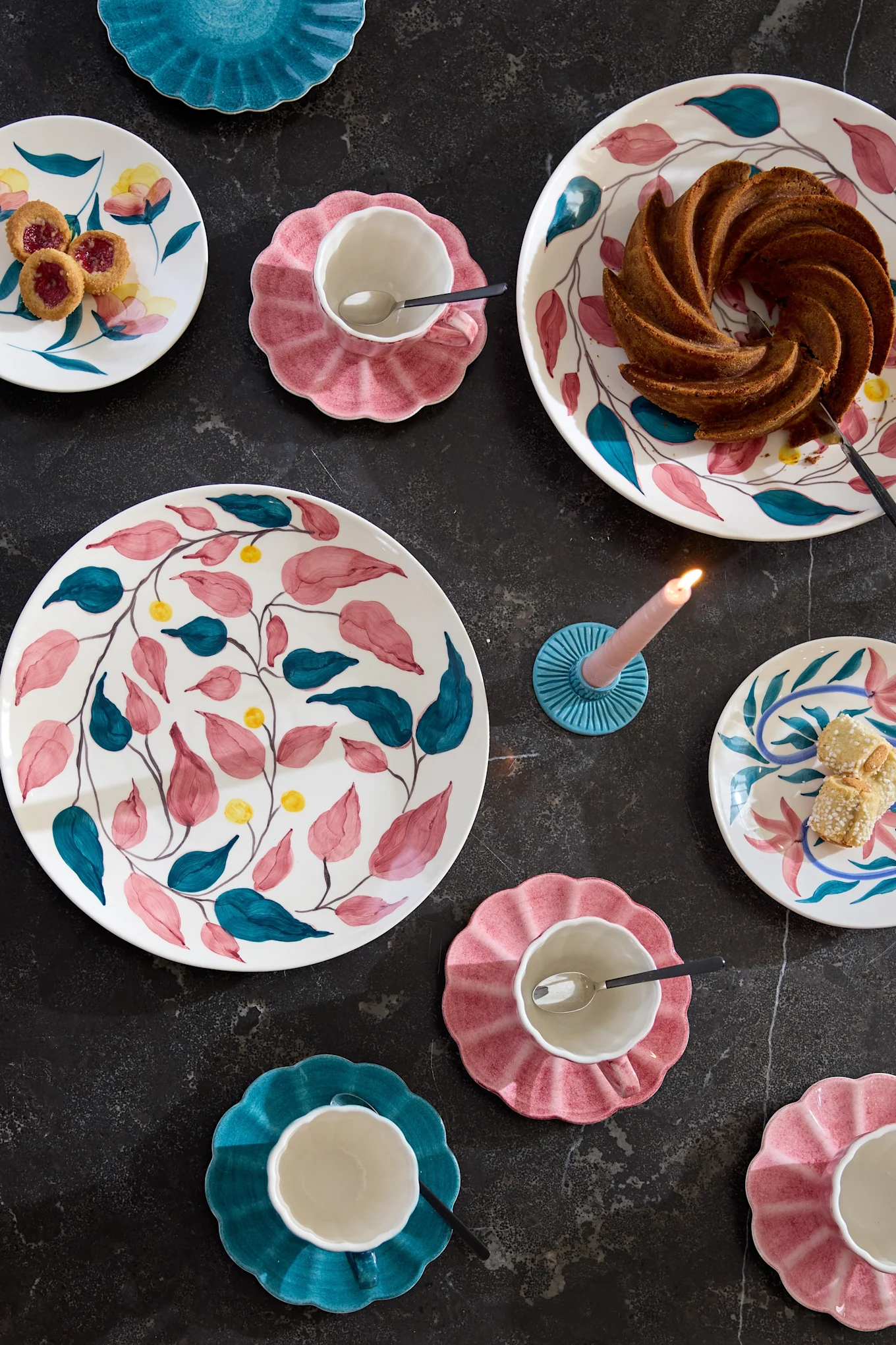 Ein gedeckter Kaffeetisch mit buntem Geschirr aus der Flowers-Kollektion von Mateus.