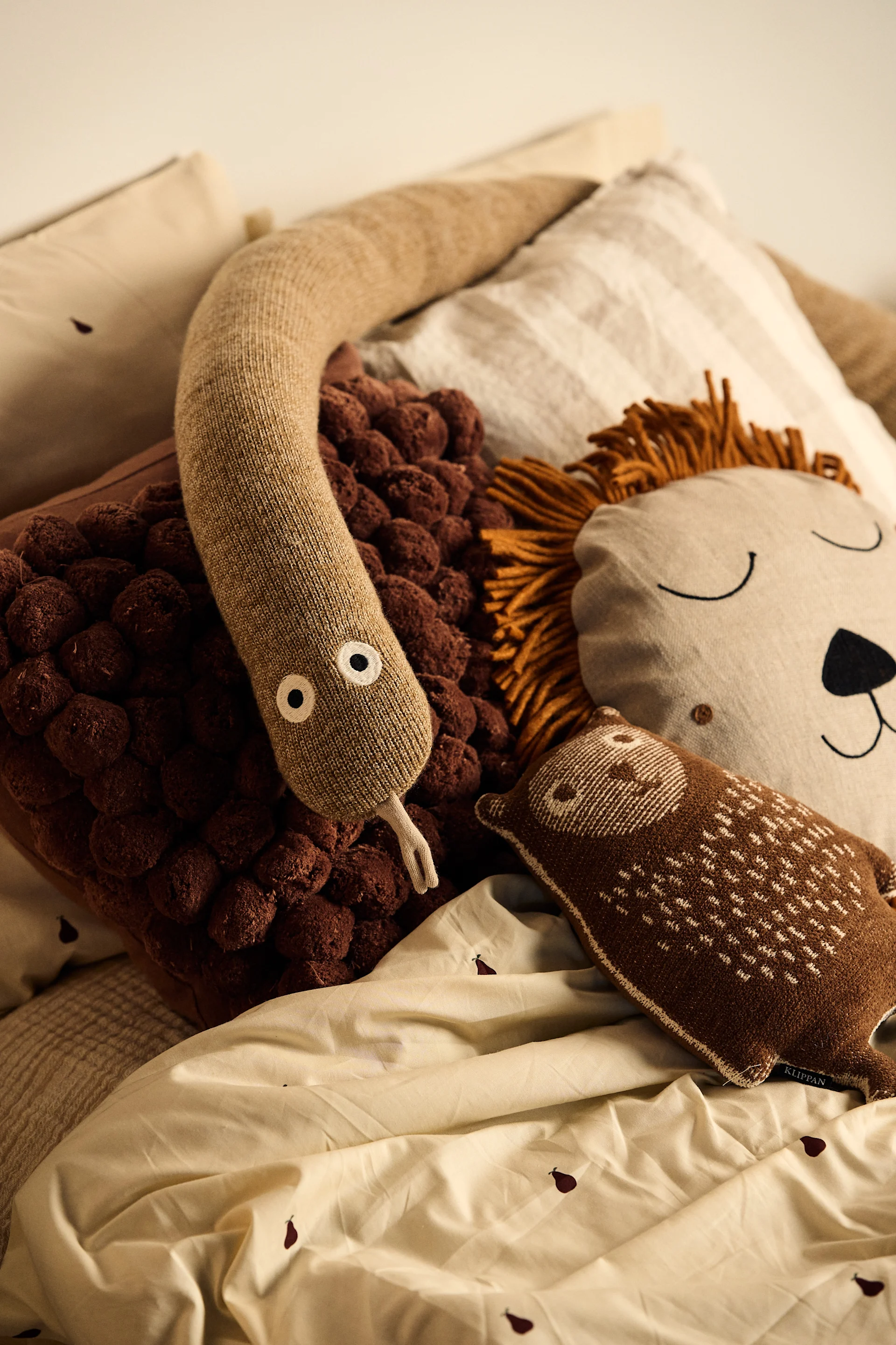 Achten Sie darauf, dass Ihr Kinderzimmer verspielt dekoriert ist. Hier sehen Sie eine Schlange und ein Löwenkissen auf dem Bett eines Kindes. 