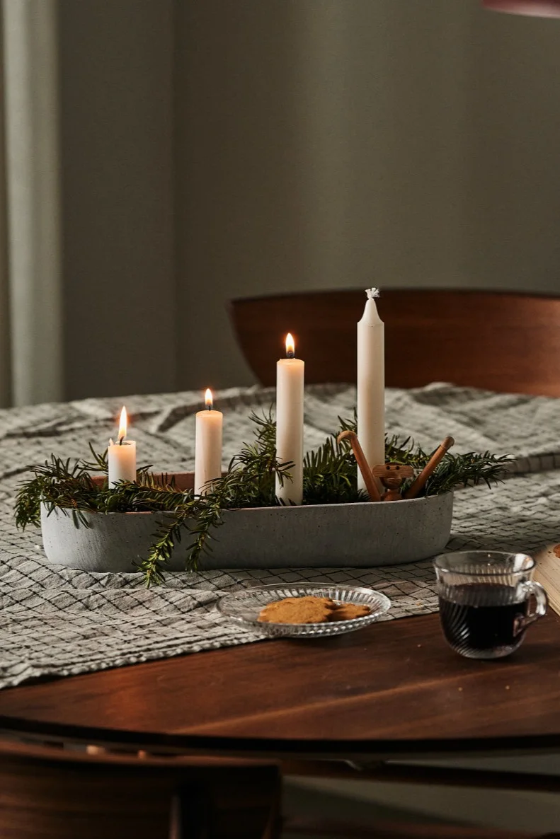 Skandinavische Weihnachtsdeko: Hier sehen Sie den Marb Kerzenhalter von House Doctor dekoriert mit Tannenzweigen auf einem Tisch stehen.