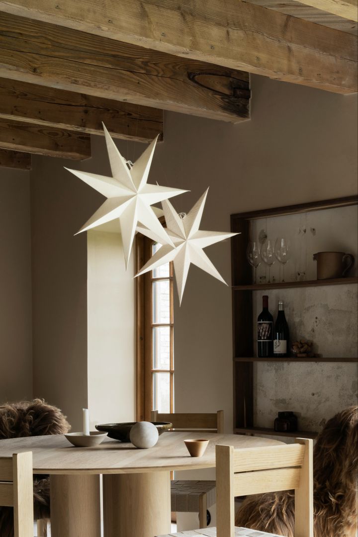 Ein Set aus zwei skandinavischen Weihnachtssternen Mira von Watt & Veke, die in einem Esszimmer hängen. 
