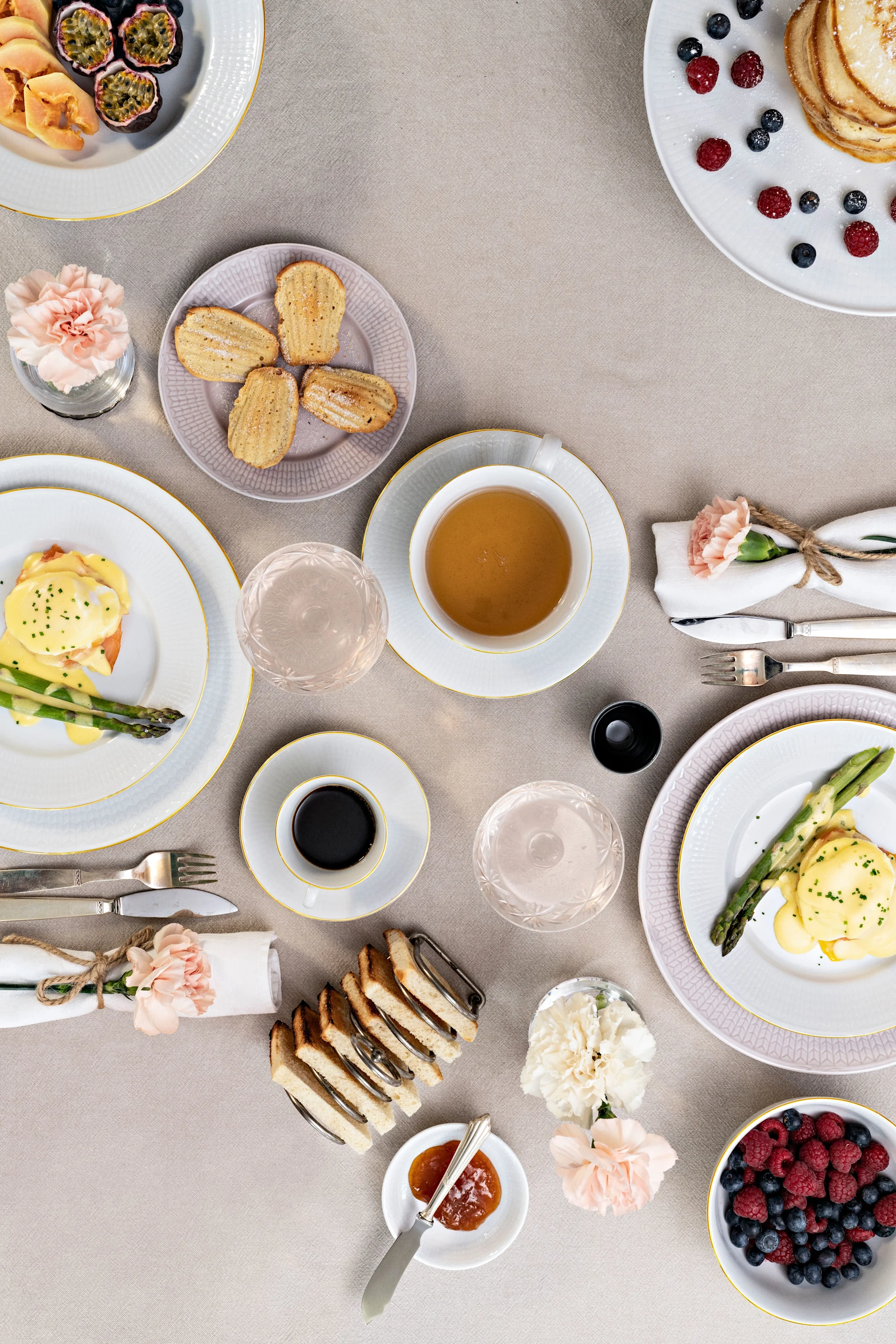 Feiern Sie den Valentinstag zu Hause mir einem besonderen Frühstück. Hier stehen mehrere Teller aus der Swedish Grace-Kollektion von Rörstrand mit Kuchen, Obst, Toast und Eiern auf einem gedeckten Tisch.