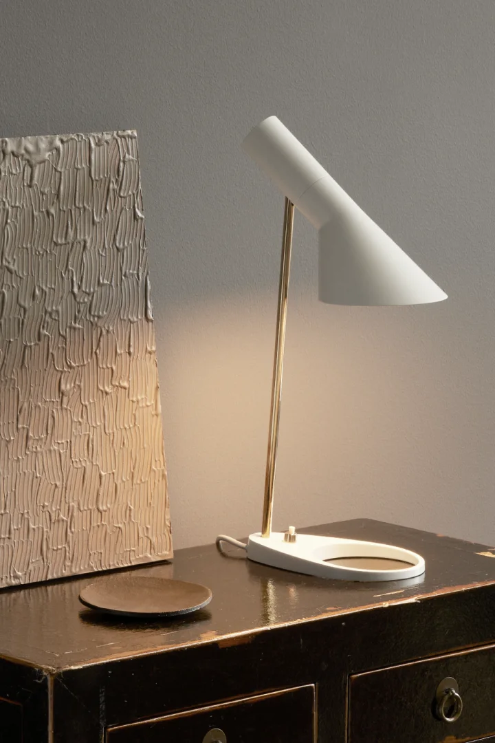 Die Leuchtenserie AJ von Arne Jacobsen ist eine der beliebtesten und ikonischsten Leuchtenserien von Louis Poulsen. Anlässlich des 150-jährigen Jubiläums der Marke wird eine Kollektion in Weiß und Hellrosa aufgelegt. Hier sehen Sie die AJ Tischleuchte.